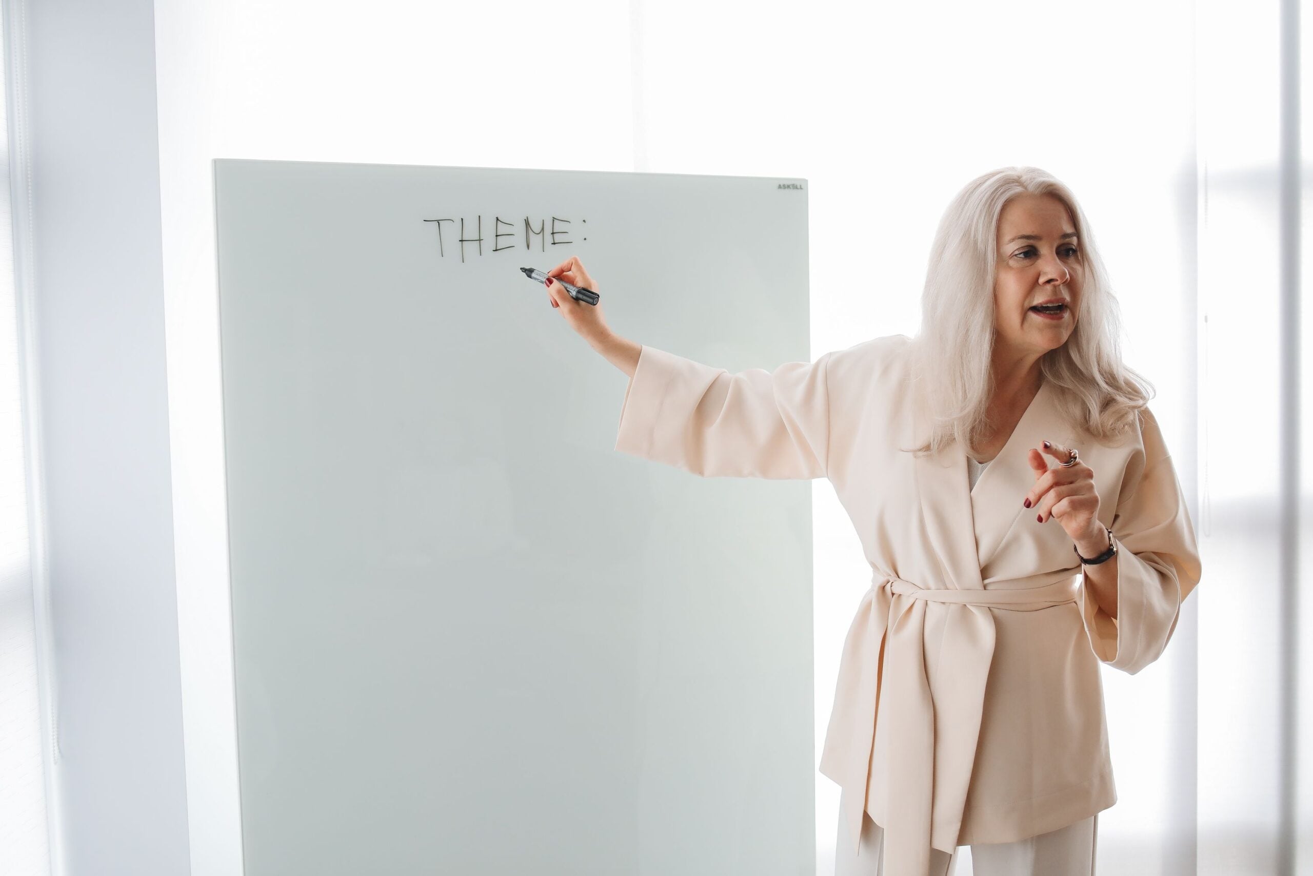 Adult instructor teaching learners at a classroom whiteboard